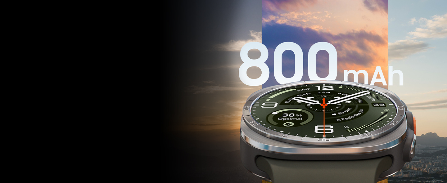Galaxy Watch Ultra2 in Titanium Silver with a Marine Band in Olive, shown up close facing front and angled upward. The background shows three different skyline and cityscape views at different times of day to demonstrate the large 800 mAh battery capacity.