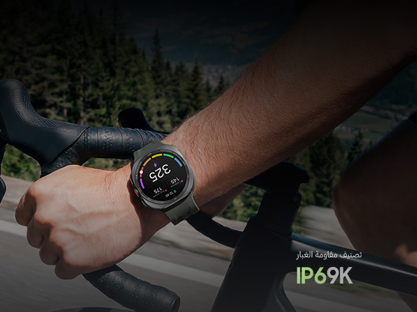 A cyclist is riding a bike on a road in the mountains while wearing a Galaxy Watch Ultra2 in Titanium Silver with a Marine Band in Olive displaying a personalized Functional Threshold Power with cadence and average power.