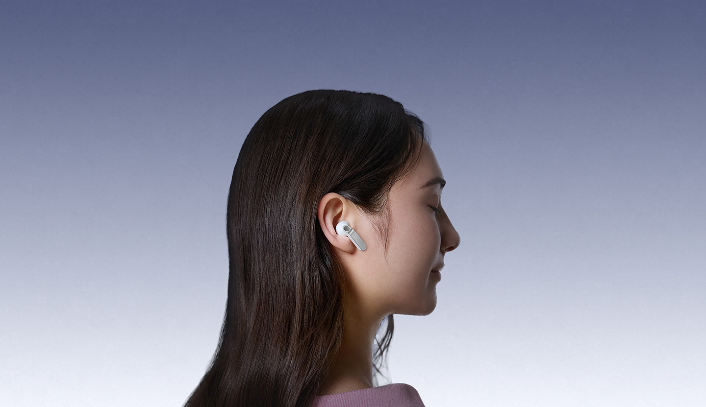 White Galaxy Buds4 earbuds in close-up, showcasing the real metal blades in different angles. Scene changes and a person is wearing Galaxy Buds4 in White, facing the right.